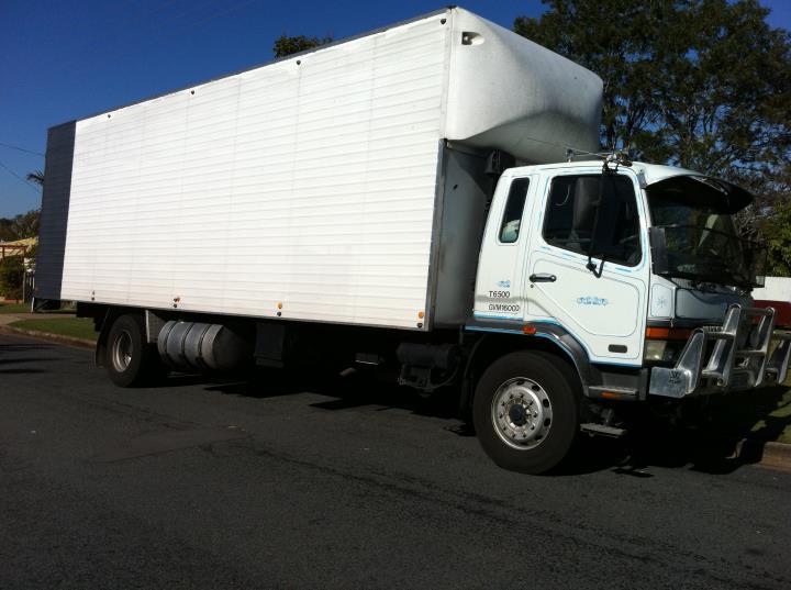 White pantech removals truck with a long body parked on a suburban street