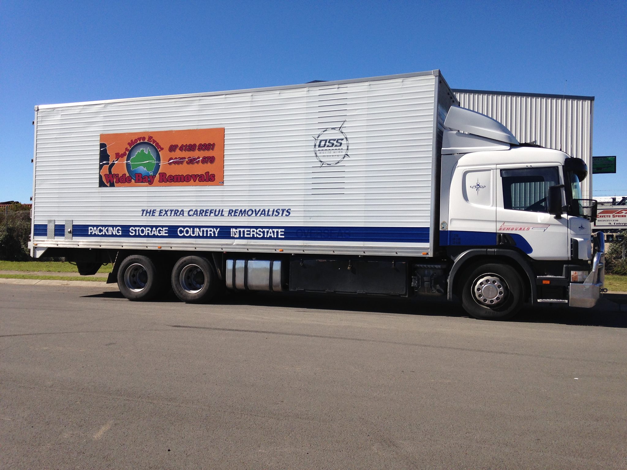 Side view of a signwritten removals truck reading The Extra Careful Removalists